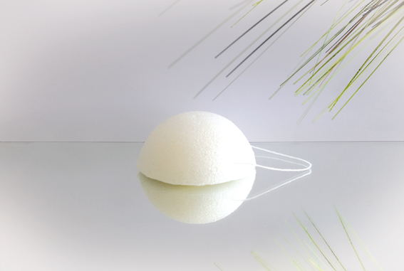 konjac-schwamm-pur-fuer-alle-hauttypen-nksp-_0 Éponge konjac blanche et ronde sur une surface réfléchissante, adaptée à tous les types de peau.